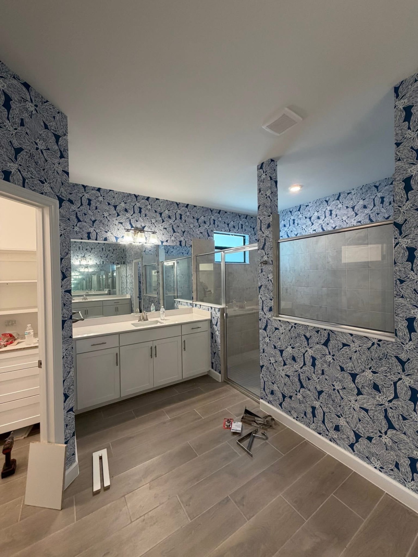 Deep blue botanical wallpaper in a luxury primary bathroom